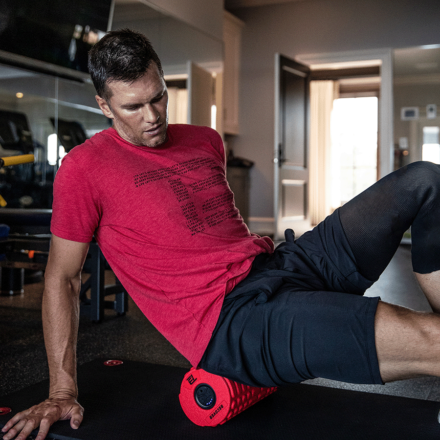 Tom Brady rolling out with a foam roller in the gym