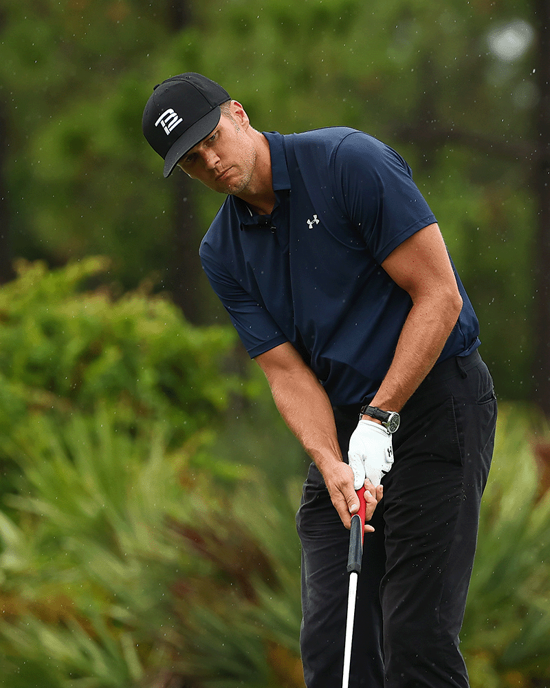 Tom Brady playing golf in a fitted hat